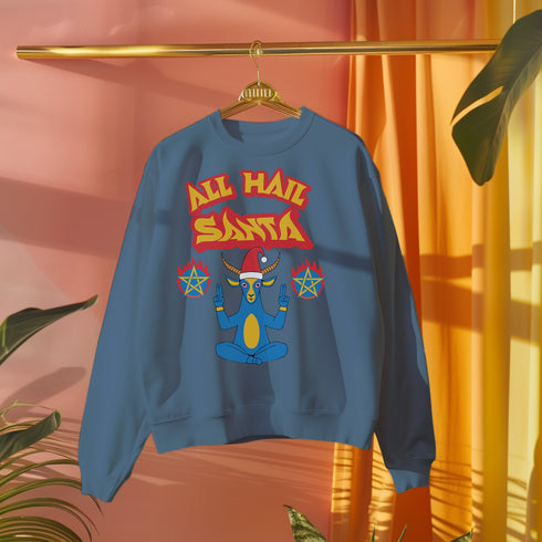 A Christmas sweatshirt featuring a playful design with a cartoon Baphomet goat character wearing a Santa hat. The design includes the text "All Hail Santa" above the goat, with pentagrams in flames on either side. The goat is depicted in a meditative pose, adding a humorous and irreverent twist to holiday attire.